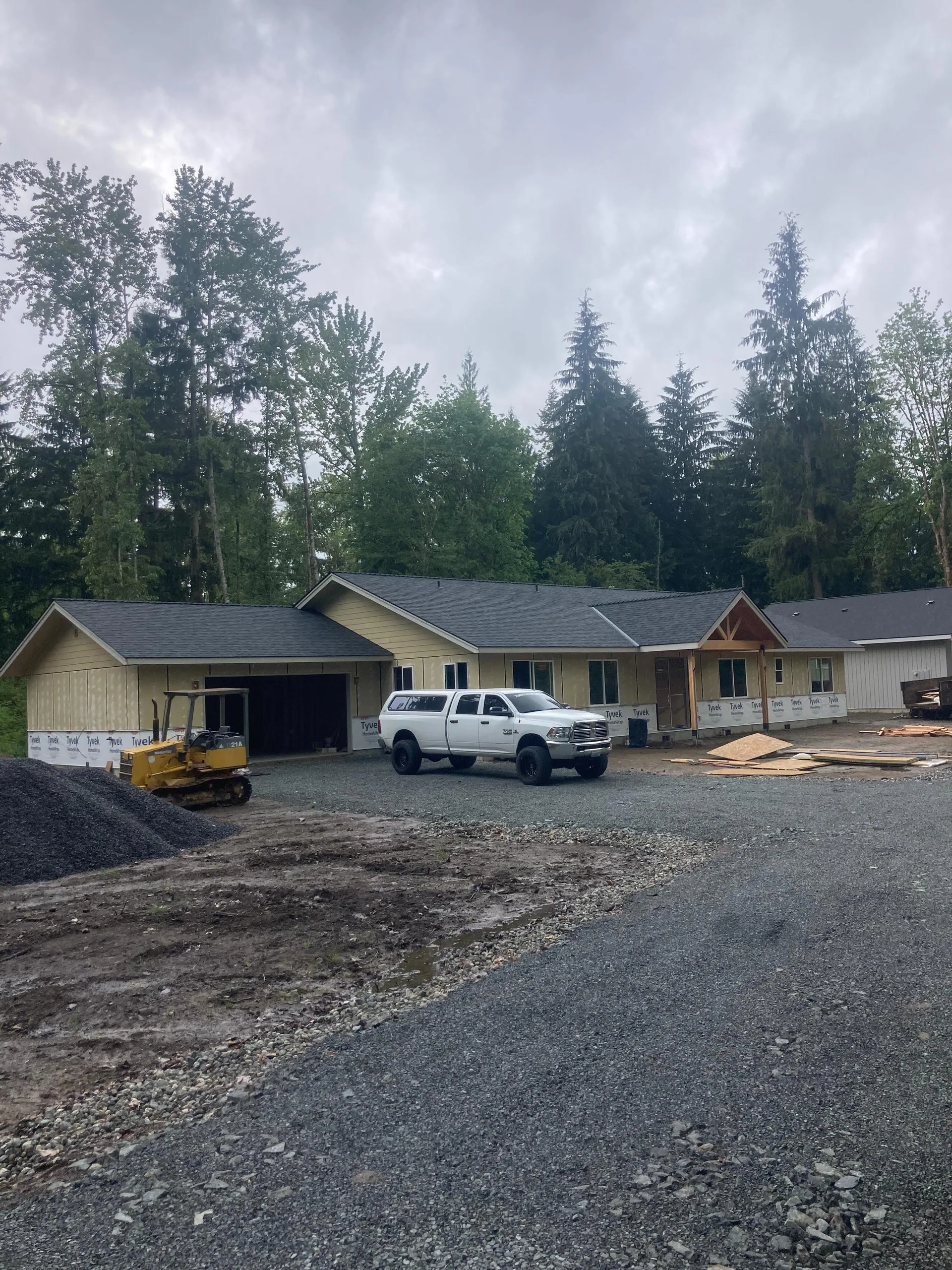 Gravel driveway bulldozer white truck new ranch home build