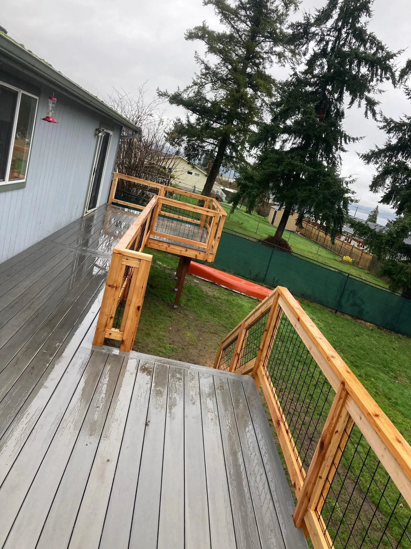 Gray composite deck cedar railing wire infill backyard