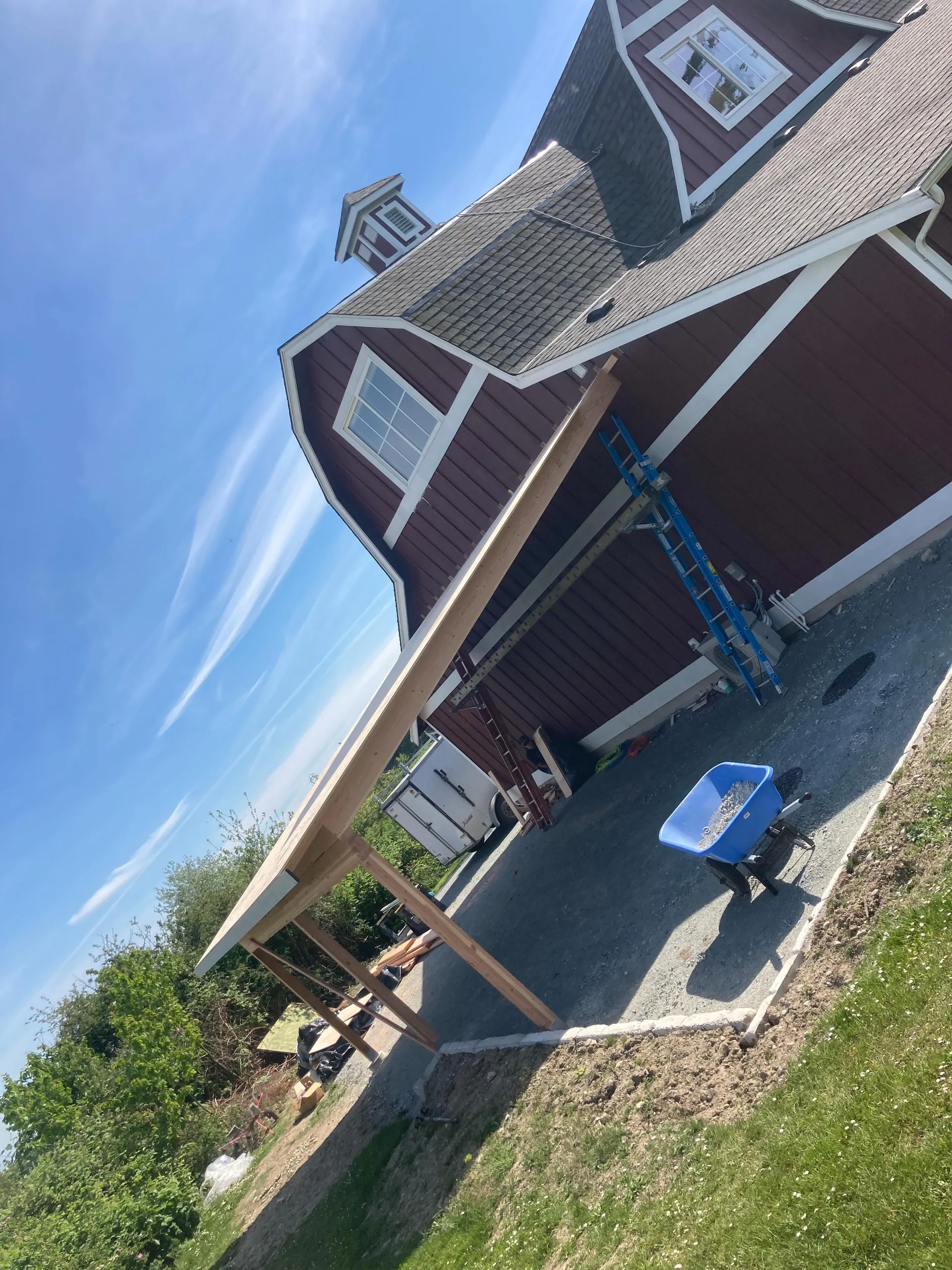 Timber carport frame red barn style house gravel pad